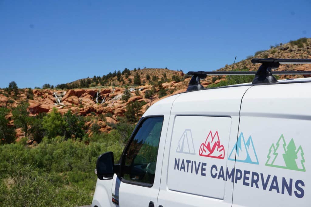 Campervan parked with waterfalls in the distance
