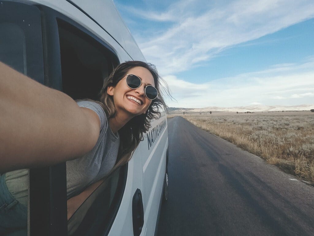 Woman looking out the window in a Campervan with driving