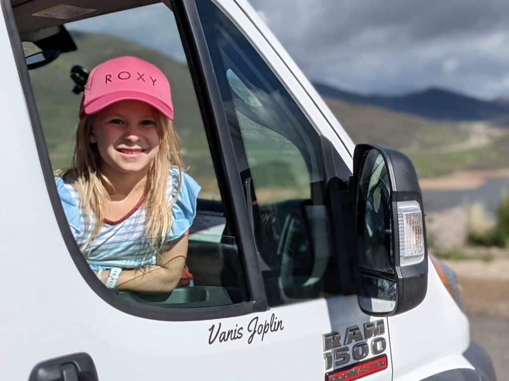 A kid in the front seat of a Campervan