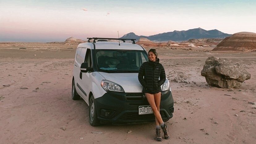 Woman standing in front of a campervan in the desert