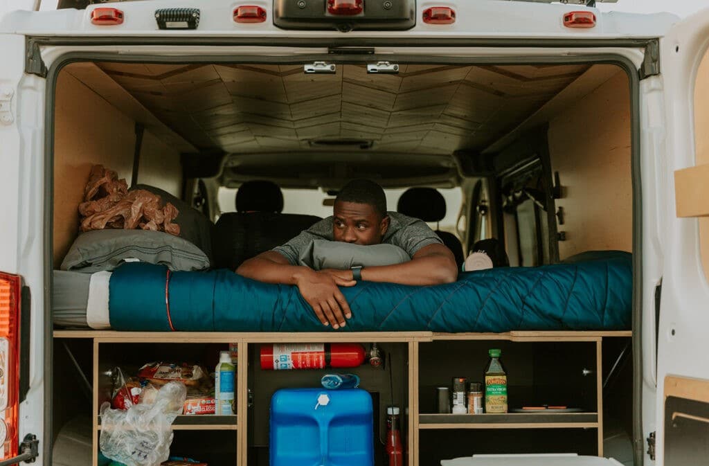 Man lying down in a campervan taking in the view