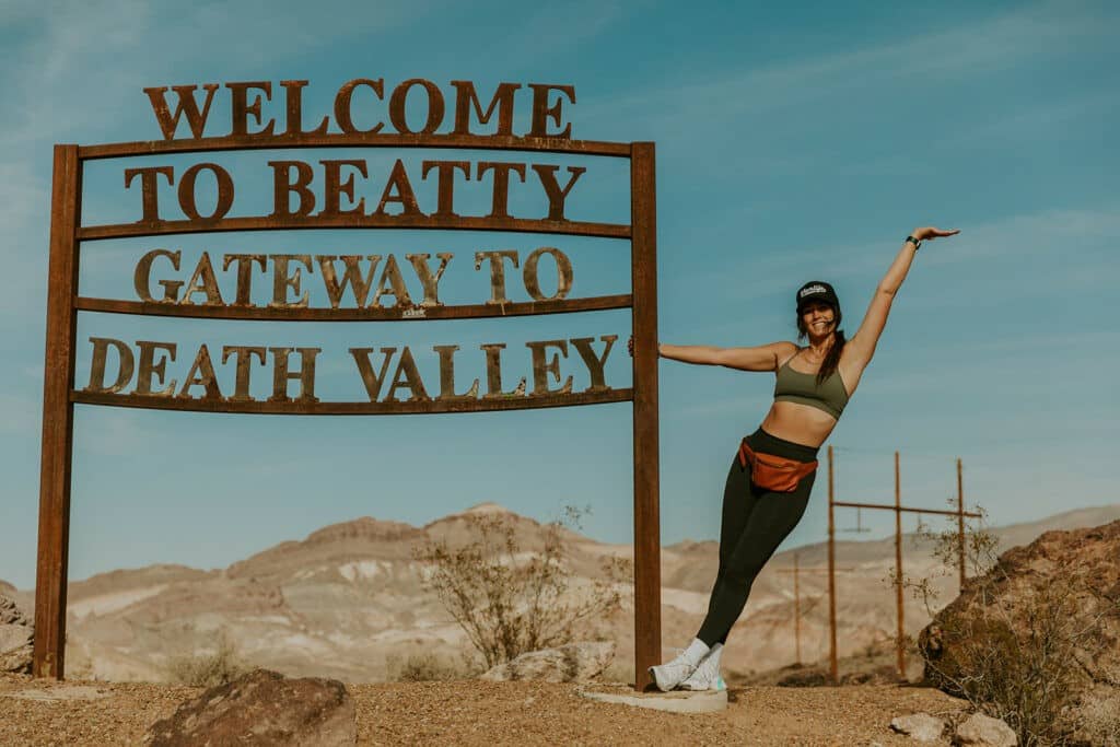 Woman posing by a sign in Death Valley National Park