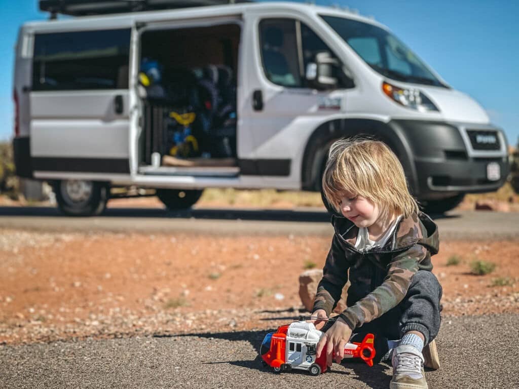 Kid playing with a toy and campervan in the background