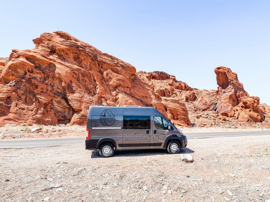 Campervan parked in front of a rock formation