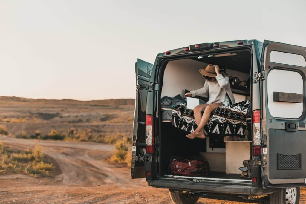 Person sitting in the back of a campervan