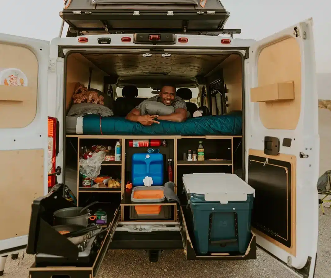 A man poses in his fully-outfitted campervan rental in Death Valley