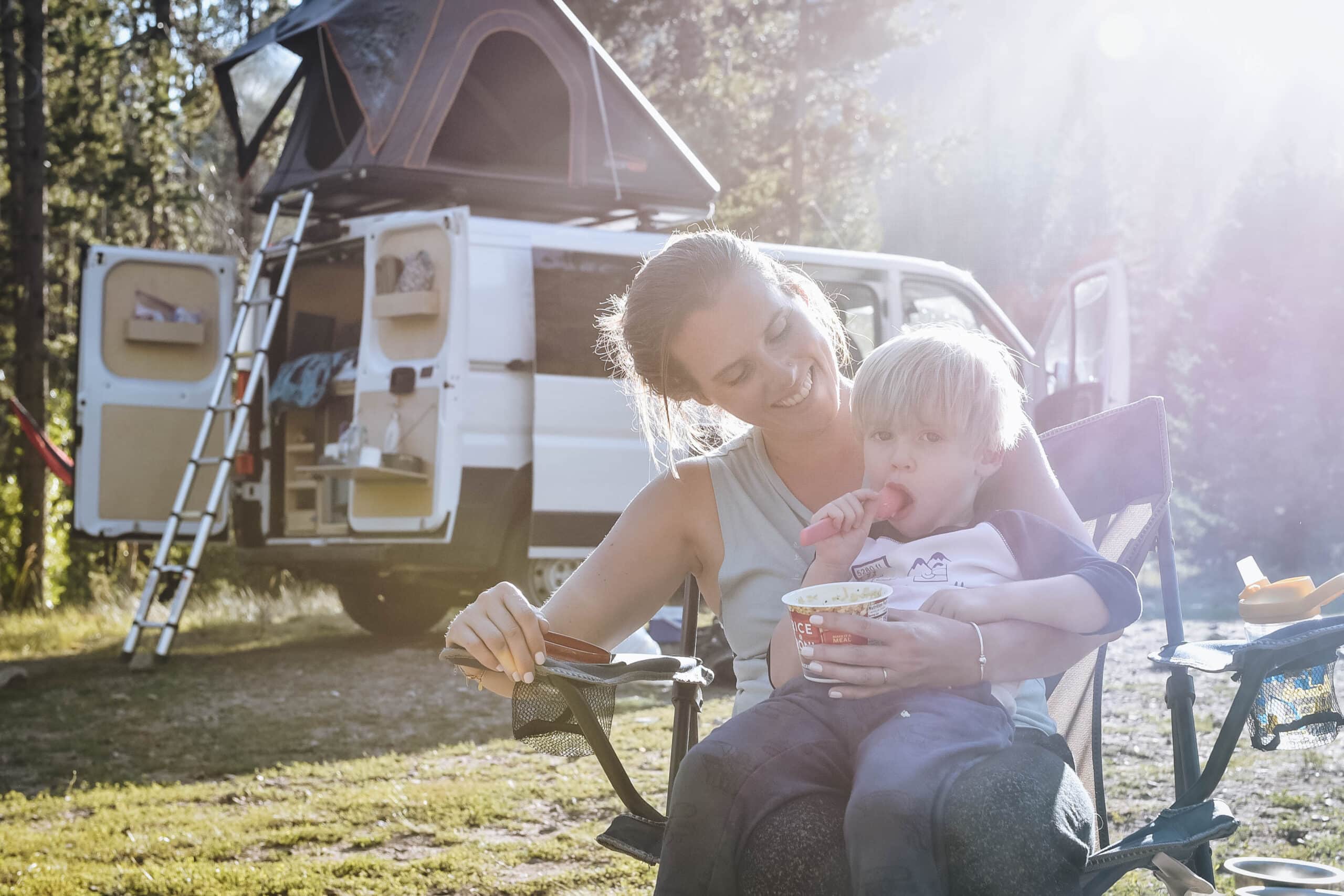 Mother and son hanging in front of a Squad Campervans rental with a roof top tent.